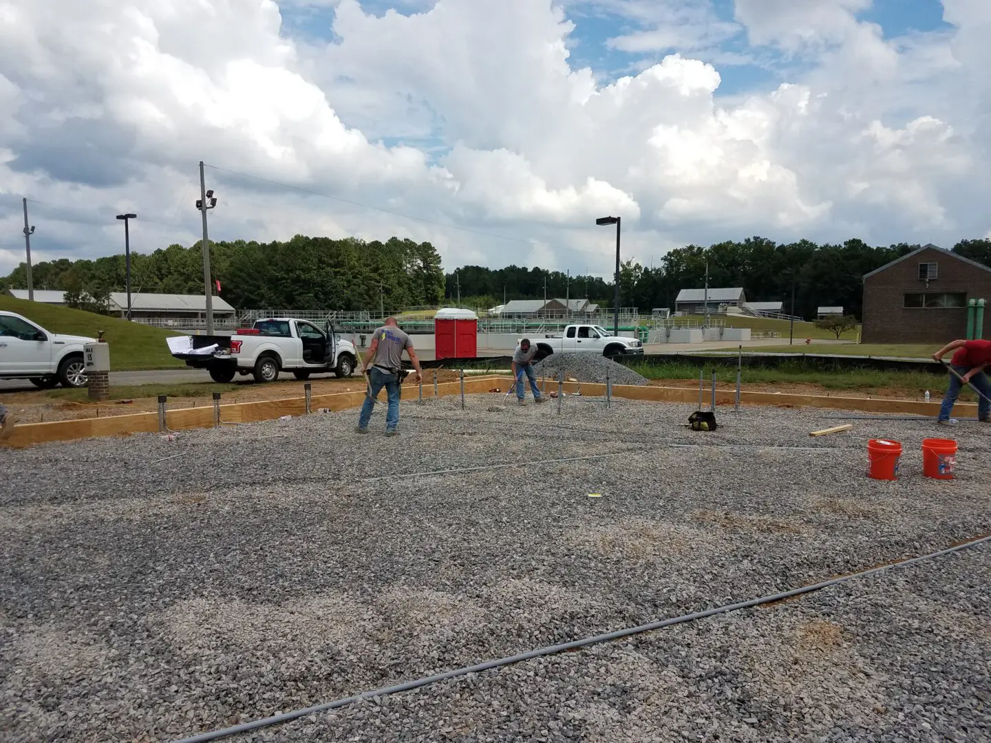 Electricians raking a field of gravel
